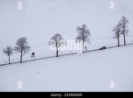 Rehefeld Zaunhaus, Allemagne. 12 février 2020. Une voiture conduit sur une route étroite au-dessus d'une montagne enneigée dans l'Erzgebirge. Une fine couche de neige attire les vacanciers vers les stations de sports d'hiver les plus élevées. Crédit: Jens Büttner/Dpa-Zentralbild/Dpa/Alay Live News Banque D'Images