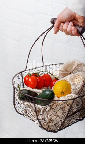 La femme garde le dos avec des légumes frais et des fuits dans des sacs textiles Banque D'Images