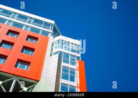 façade d'un bâtiment moderne dans le style d'un mur rouge de haute technologie, fenêtres carrées sur une journée ensoleillée avec ciel bleu clair. Espace pour le texte. Vue de dessous Banque D'Images