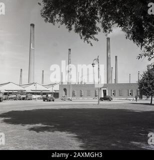 Années 1950, historique, extérieur de la briqueterie stewartby à la London Brick Company (LBC) Bedford, Angleterre, montrant le grand nombre de cheminées à l'usine, à cette époque, la plus grande dans le monde. À cette époque, Stewartby avait 32 cheminées mesurant chacune 70 mètres de haut et imposaient des repères industriels sur un paysage rural environnant. Les LBC étaient des employeurs paternels dans le moule des sociétés quaker de la fin de l'époque victorienne et ont construit un « village modèle » à Stewartby, fournissant à leurs employés des logements en briques et de vastes installations sociales et de loisirs. Banque D'Images