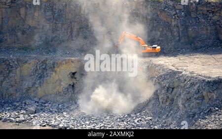 creuseur orange travaillant dans la carrière de granit Banque D'Images