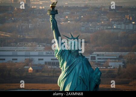 Coucher de soleil sur la Statue de la liberté dans le port de New York, New York. Banque D'Images