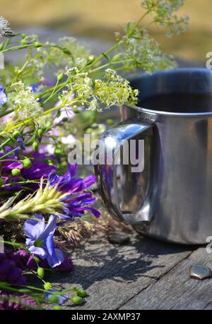 tasse à poignée en fer avec fleurs violettes sur le snrom de table en bois Banque D'Images