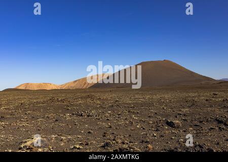 Roches volcaniques près du parc national de Timanfaya contre le ciel bleu sans nuages à Lanzarote, îles Canaries Banque D'Images