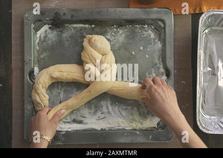 Image rognée de pâte tressée pour pain de Challah dans un plateau à la table Banque D'Images