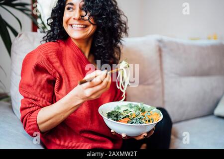 Femme brunette mangeant une salade verte saine. Banque D'Images