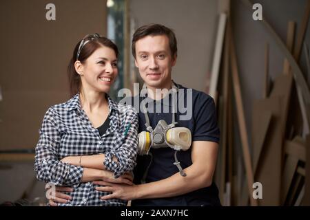 Homme et femme menuisiers assis en atelier sur fond de conseils Banque D'Images