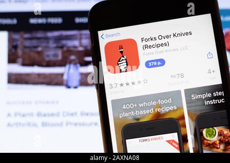 Los Angeles, Californie, États-Unis - 12 février 2020: Téléphone mobile avec l'icône Forks Over Knives à l'écran gros plan avec le site Web sur ordinateur portable, illustratif Banque D'Images