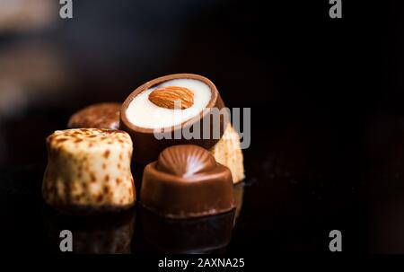 Bonbons au chocolat avec amandes sur fond sombre Banque D'Images