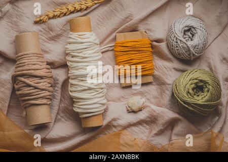 Cordes Macrame de différentes couleurs, vue de dessus. Filets de moutarde, d'olive et de crochet blanc en toile de fond pastel, image plate Banque D'Images