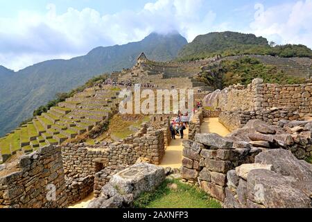 Vue partielle sur les terrasses et les maisons de la ville de ruines de Machu Picchu au-dessus de la vallée d'Urubamba près d'Aguas Calientes, Andes, Pérou, UNESCO-monde Banque D'Images