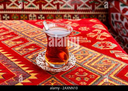Tasse de thé turc chaud sur une table avec Tablecloth turc traditionnel Banque D'Images
