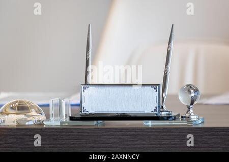 Porte-nom argenté et porte-stylo sur la table de bureau Banque D'Images