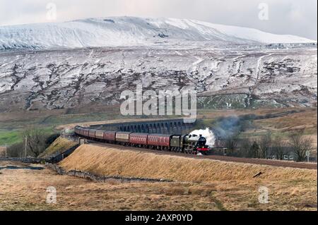 Ribblehead, Yorkshire Du Nord, Royaume-Uni. 12 janvier 2020.le spécial vapeur « Pendle Dalesman », transporté par « Alberta » 45562 (en fait le moteur « Galatea » 45699 en nouveau faux mensonger), est vu ici en traversant le célèbre viaduc Ribblehead dans le parc national du Yorkshire Dales, en direction sud de Carlisle sur la célèbre ligne Ferroviaire De Carlisle. Un pic de Whernside neigeux est vu en arrière-plan. Crédit: John Bentley/Alay Live News Banque D'Images