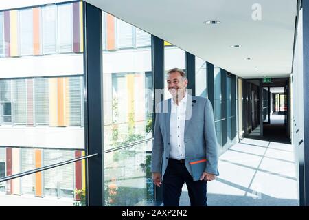 Homme d'affaires d'âge moyen dans un immeuble de bureaux moderne Banque D'Images