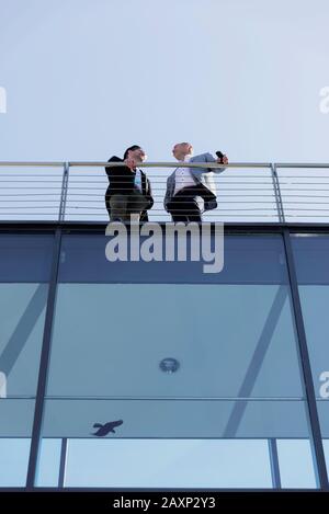 Deux personnes en voyage d'affaires sur le balcon d'un immeuble de bureaux moderne Banque D'Images