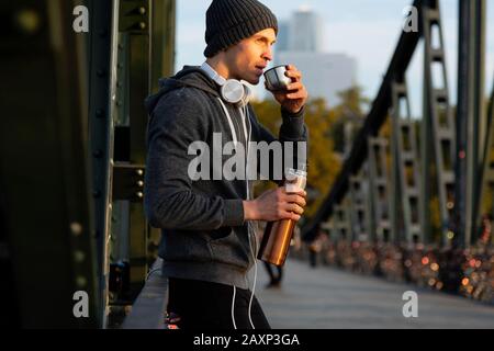 L'homme sportif a une pause tout en faisant du jogging en ville, demi-portrait Banque D'Images