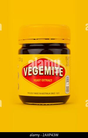 Un pot de Vegemite tourné sur un fond jaune. Banque D'Images