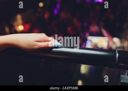 La femme à l'aide d'une rambarde d'aller à l'étage avec un fond gris clair Banque D'Images