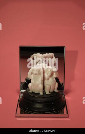 trois singes sages sur plinthe en bois se reflète dans le miroir, contre fond rose Banque D'Images