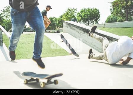 Groupe d'amis de patineurs exécutant le tour dans le parc pubblica - entraînement des jeunes hommes avec des planches à roulettes - sport extrême, concept de style de vie de jeunesse - se concentrer sur le beh Banque D'Images