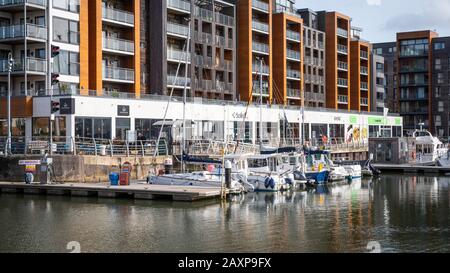 Portishead Quay Marina, Angleterre Royaume-Uni: Yachts amarré devant des magasins, un café et des appartements. Banque D'Images