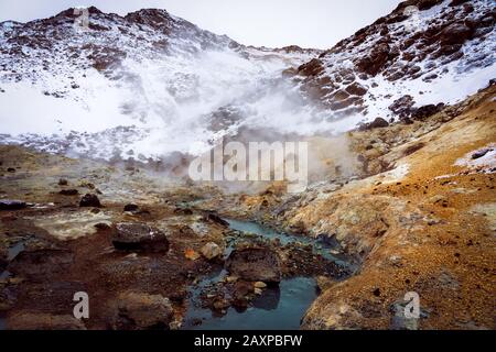Rivière chaude et montagnes dans la neige dans le krysuvik seltun sur la péninsule de reykjanes en Islande paysage d'hiver . Banque D'Images