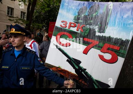 Sébastopol, Crimée, 9 mai 2019 l'officier russe tient une bannière avec une photographie du système soviétique de missiles surface-air S-175 lors d'un défilé militaire du jour de la Victoire sur l'avenue Nakhimova marquant le 74ème anniversaire de la victoire sur l'Allemagne nazie lors de la Grande Guerre patriotique de 1941-45 Le front oriental de la seconde Guerre mondiale L'inscription Russiam indique « complexe de missiles anti-aéronefs S-75 » Banque D'Images
