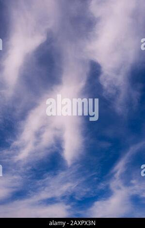 Cirrus nuages dans le ciel bleu avec des nuages formant un visage. Banque D'Images
