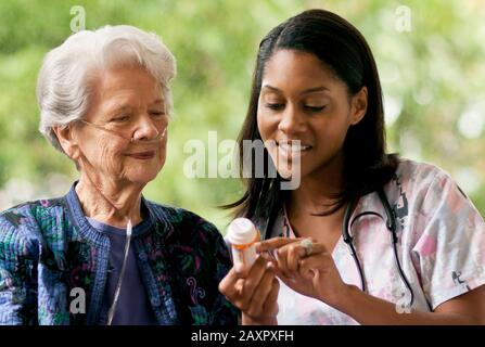 Infirmière expliquant comment prendre des médicaments pour un senior patient. Banque D'Images