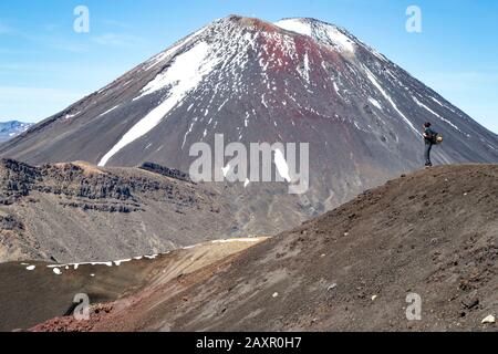 Randonneur mâle avec sac à dos, regardant la vue et un volcan neigé Banque D'Images