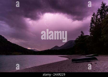 Une tempête de foudre sur le bateau amarrer au lac Walchensee dans les alpes bavaroises. Banque D'Images