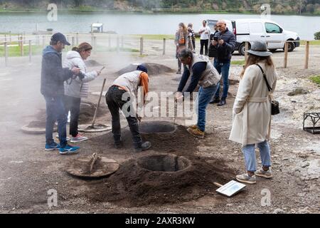 Furnas, Açores - février 2020: Trois hommes enlevant 'Cozido das Furnas', des aliments cuits aux ouvertures volcaniques de l'île de Sao Miguel, aux Açores, au Portugal Banque D'Images