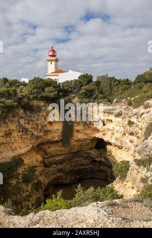 Trou de roche naturel et phare d'Alfanzina à Carvoeiro, Algarve, Faro district, Portugal Banque D'Images