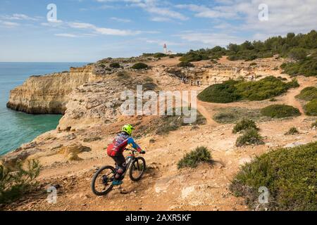 Cyclistes sur le sentier des sept vallées suspendues (Percurso dos Sete Vales Suspensos), aussi sentier Lagoa-PR1, à Cabo Carvoeiro, derrière un trou de sinkhole et Banque D'Images