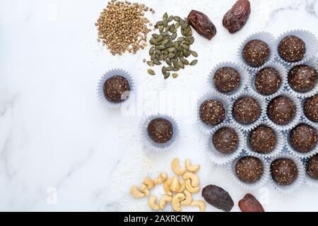 Graines de dattes et boulettes d'énergie à base de noix végan maison. Fait avec des dattes de médules, noix de cajou, chanvre, graines de tournesol et de citrouille et noix de coco déshydratée Banque D'Images