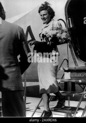 1937 , STOCKHOLM , SUÈDE : le réalisateur allemand de films nazis et l'actrice LENI RIEFENSTAHL ( 1902 - 2003 ) , ami D'ADOLF HITLER , arrivée à Stockholm par avion de Copenhague , Comme un représentant officiel de la Reich nazie allemande pour présenter son film "Olympia" , tournage des derniers Jeux olympiques d'été à Berlin 1936 . - NAZI - NAZISMO - NAZISTA - 2ème Guerre mondiale - SECONDA GUERRA MONDIALE - DONNA REGISTA - CINÉMA - FILM - sourire - sorriso - orchidea - aéroplano - aeroporto - aéroport - fleurs - fiori - fiore - borsetta - borsa - sac à main - SVEZIA - Stoccolma - fleurs chaussures - scarpe - sandali - sable Banque D'Images