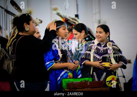 San Francisco, États-Unis - 08 février 2020: Les filles indiennes indigènes dans la robe traditionnelle complexe de jingle se préparant à danser à un powwow Banque D'Images