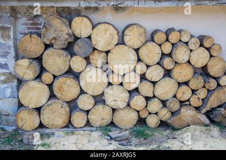 Pile de grands bois ronds devant une maison. Grumes, carburant pour chauffage. Bois de chauffage empilé. Fond en bois naturel Banque D'Images