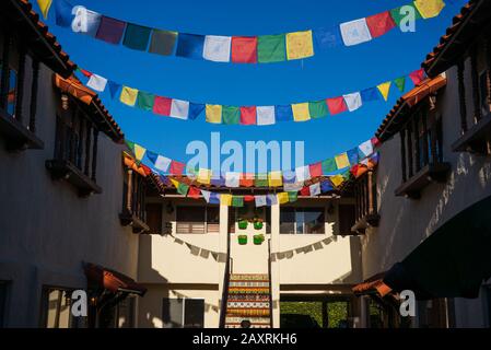 Cour de l'immeuble d'appartements du sud de la Californie avec drapeaux de prière colorés et un ciel bleu brillant Banque D'Images