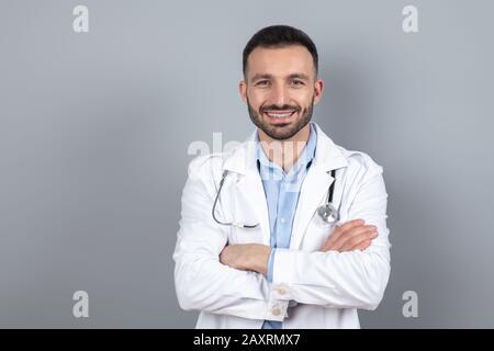 Médecin dans un peignoir blanc souriant positivement Banque D'Images