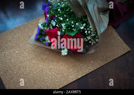 bouquet de roses arrangements de fleurs dans un emballage en papier sur fond en bois Banque D'Images