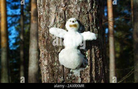 Le Snowman figurine sur un tronc d'arbre. Les personnages de conte de Noël l'hiver Banque D'Images