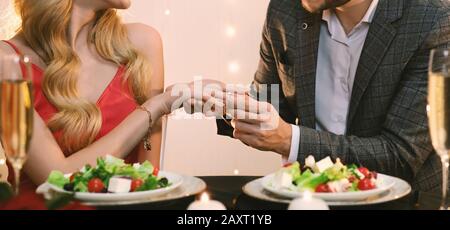 Bague De Mise En Forme Homme Imreconnaissable Sur La Main De La Petite Amie Pendant Le Dîner Au Restaurant Banque D'Images