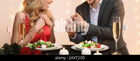 Homme faisant la proposition de mariage à la petite amie surprise pour dîner au restaurant Banque D'Images