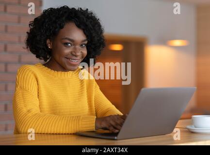 Portrait de la jeune femme d'affaires utilisant un ordinateur portable au café Banque D'Images