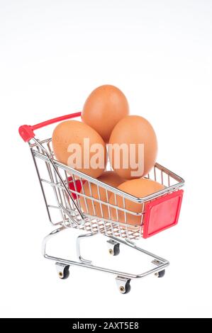 Œufs équilibrés dans un panier sur fond blanc Banque D'Images