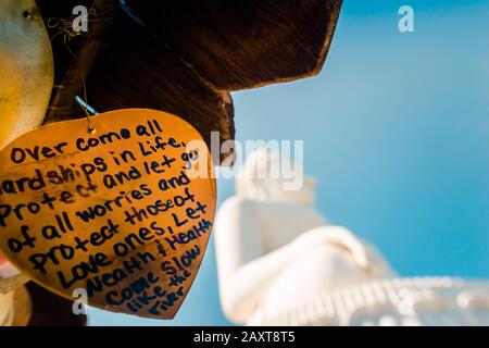 Nakkerd Hill, Phuket/Thailand-15December2019: Des cloches de prière en forme de coeur doré pendent ensemble dans une rangée avec des notes spirituelles de personnes écrites sur eux Banque D'Images