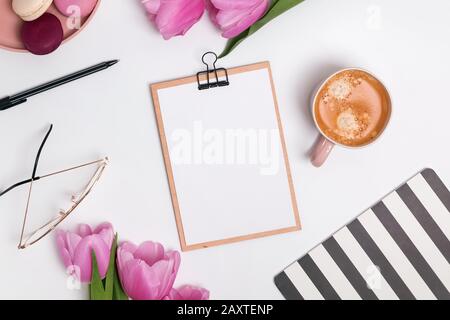 Lieu de travail féminin avec tulipes et café. Banque D'Images