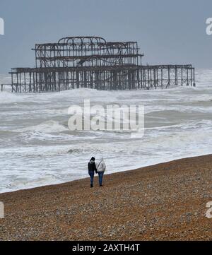 Brighton Royaume-Uni 13 février 2020 - Walkers brave le temps humide et venteux sur la plage de Brighton près de West Pier alors que Storm Dennis approche la Grande-Bretagne avec des vents violents et des inondations qui devraient causer plus de dégâts ce week-end prochain: Crédit Simon Dack / Alay Live News Banque D'Images